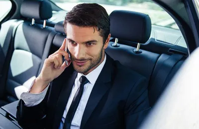 Comfort Drive corporate driver holding open the car door for a business executive in Dubai