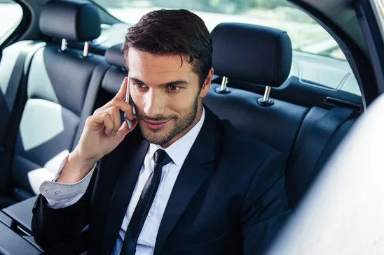 Comfort Drive executive driver beside a client's car in Dubai's business district